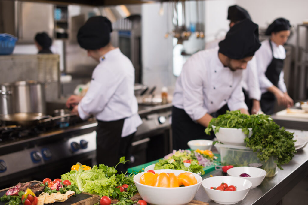 Team di cuochi e chef preparano pasti in cucina professionale - ProntoPast