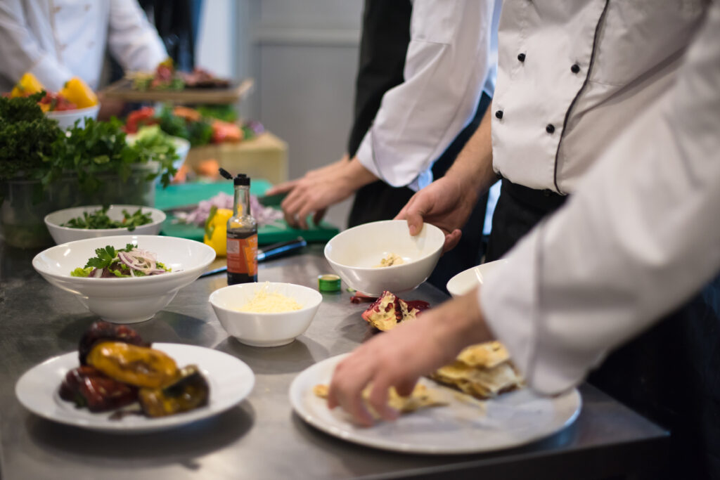 Team di cuochi e chef prepara pasti in cucina professionale - ProntoPast